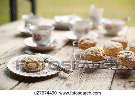 Stock Image - Table with fresh baked scones and afternoon tea. Fotosearch