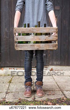 Teenage boy carrying empty bottles in wooden crate View Large Photo Image Stock Image - Teenage boy carrying empty bottles in wooden crate. Fotosearch