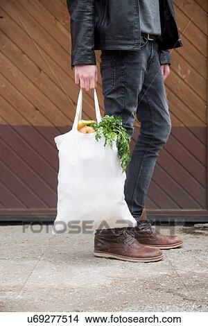 Teenage boy carrying reusable shopping bags full of fresh fruit and veg View Large Photo Image Picture - Teenage boy carrying reusable shopping bags full of fresh fruit and veg. Fotosearch