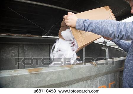 Teenage boy emptying paper waste to recycling bin View Large Photo Image Stock Photo - Teenage boy emptying paper waste to recycling bin. Fotosearch