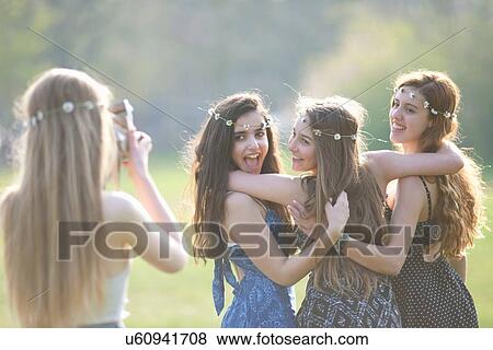 Teenage girl photographing three friends using instant camera in park View Large Photo Image Stock Photo - Teenage girl photographing three friends using instant camera in park. Fotosearch
