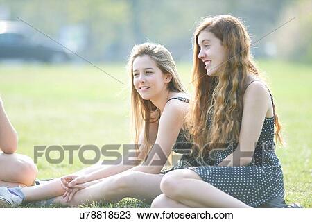 Teenage girls sitting in park chatting View Large Photo Image Stock Image - Teenage girls sitting in park chatting. Fotosearch