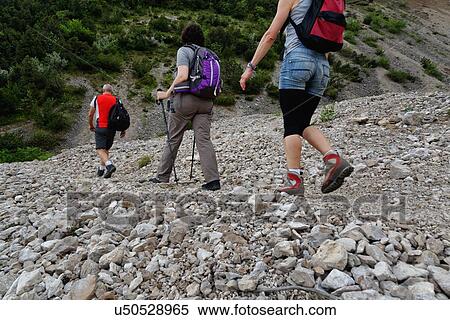 Three mature hikers hiking in stoney valley View Large Photo Image Stock Photography - Three mature hikers hiking in stoney valley. Fotosearch