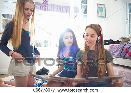 Three teenage girls looking at vinyl record cover in bedroom View Large Photo Image Stock Photo - Three teenage girls looking at vinyl record cover in bedroom. Fotosearch