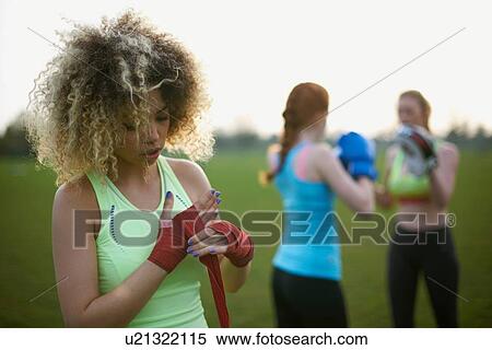 Stock Photography - Three women exercising with boxing gloves in the park. Fotosearch