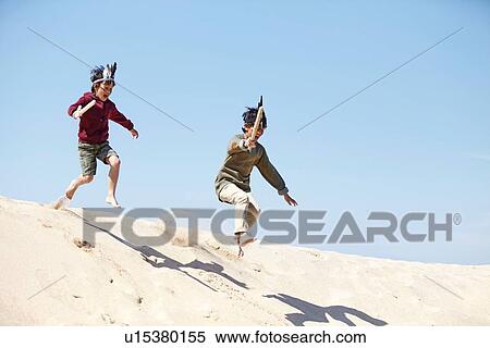 Stock Photography - Two boys, wearing fancy dress, playing on sand. Fotosearch