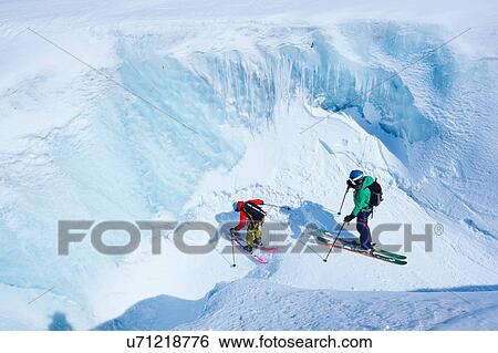 Two male skiers skiing down ravine on Mont Blanc massif, Graian Alps, France View Large Photo Image Stock Photograph - Two male skiers skiing down ravine on Mont Blanc massif, Graian Alps, France. Fotosearch