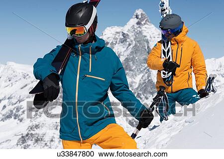 Two men carrying skis in snow, Zermatt, Valais, Switzerland View Large Photo Image Stock Image - Two men carrying skis in snow, Zermatt, Valais, Switzerland. Fotosearch