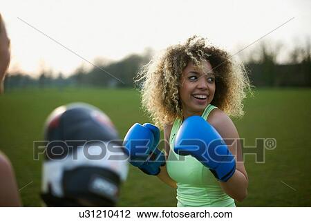 Two women exercising with boxing gloves in the park View Large Photo Image Stock Image - Two women exercising with boxing gloves in the park. Fotosearch