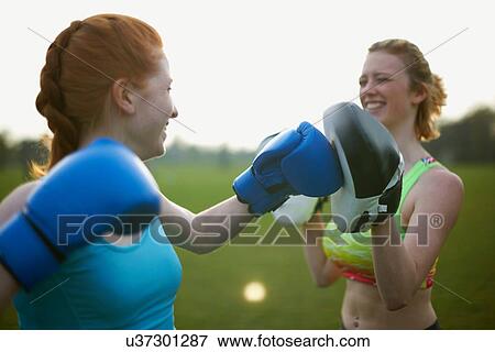 Two women exercising with boxing gloves in the park View Large Photo Image Stock Photo - Two women exercising with boxing gloves in the park. Fotosearch