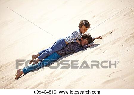 Two young boys lying on sandy hill, playing View Large Photo Image Stock Image - Two young boys lying on sandy hill, playing. Fotosearch