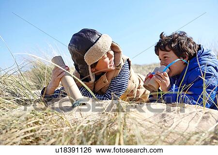 Stock Photograph - Two young boys on beach, holding pretend binoculars. Fotosearch