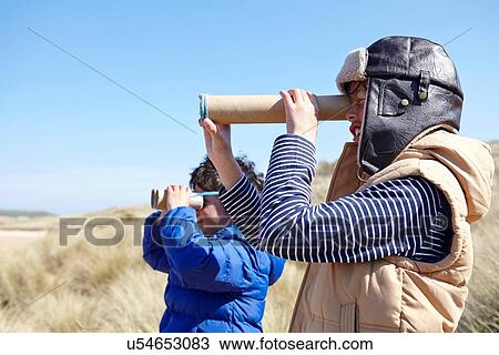 Two young boys on beach, looking through pretend binoculars View Large Photo Image Stock Image - Two young boys on beach, looking through pretend binoculars. Fotosearch