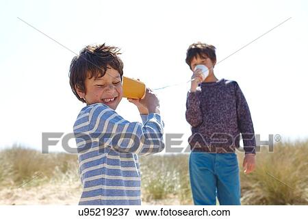 Two young boys, playing with cup and string telephone View Large Photo Image Stock Photo - Two young boys, playing with cup and string telephone. Fotosearch
