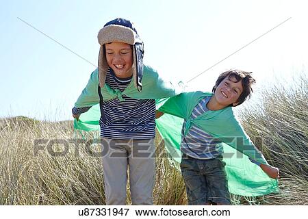 Two young boys, wearing fancy dress, playing on beach View Large Photo Image Stock Photo - Two young boys, wearing fancy dress, playing on beach. Fotosearch
