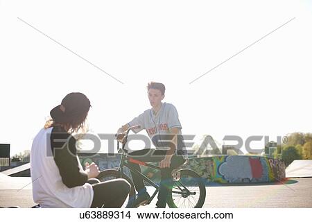Two young men on bmx bikes at skatepark View Large Photo Image Picture - Two young men on bmx bikes at skatepark. Fotosearch
