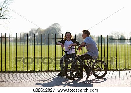 Stock Photo - Two young men on bmx bikes at skatepark. Fotosearch
