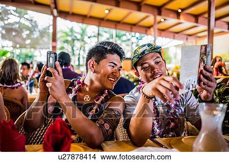 Two young men reading menu in Polynesian Cultural Centre, Hawaii, USA View Large Photo Image Picture - Two young men reading menu in Polynesian Cultural Centre, Hawaii, USA. Fotosearch