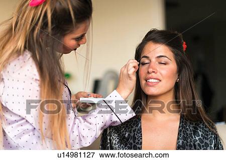 Two young women, applying make-up View Large Photo Image Stock Photo - Two young women, applying make-up. Fotosearch