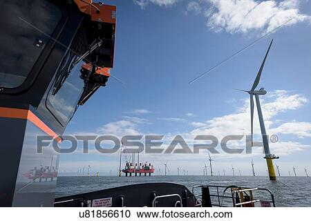 Stock Image - View of offshore wind farm and construction ship from boat. Fotosearch