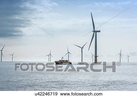 Stock Photo - View of offshore windfarm and service boat. Fotosearch