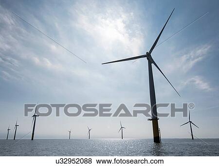 Stock Photo - View of silhouetted offshore windfarm from service boat. Fotosearch