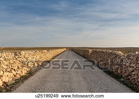 View of straight rural road between dry stone walls, Menorca, Spain View Large Photo Image Stock Photo - View of straight rural road between dry stone walls, Menorca, Spain. Fotosearch
