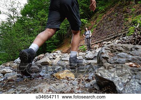 Waist down rear view of mature male hiker hiking in stream View Large Photo Image Stock Image - Waist down rear view of mature male hiker hiking in stream. Fotosearch