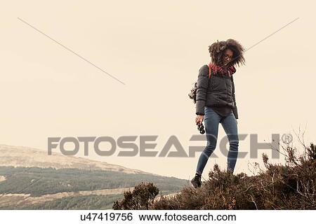 Stock Photograph - Woman hiking, looking down. Fotosearch