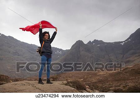 Woman holding red flag in mountains, Fairy Pools, Isle of Skye, Hebrides, Scotland View Large Photo Image Picture - Woman holding red flag in mountains, Fairy Pools, Isle of Skye, Hebrides, Scotland. Fotosearch