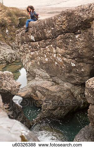 Woman sitting on rocks, Fairy Pools, Isle of Skye, Hebrides, Scotland View Large Photo Image Stock Photo - Woman sitting on rocks, Fairy Pools, Isle of Skye, Hebrides, Scotland. Fotosearch