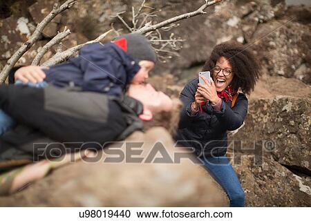 Woman taking photo of man holding son, laughing View Large Photo Image Stock Image - Woman taking photo of man holding son, laughing. Fotosearch