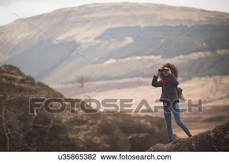 Woman using binoculars, Fairy Pools, Isle of Skye, Hebrides, Scotland View Large Photo Image Stock Image - Woman using binoculars, Fairy Pools, Isle of Skye, Hebrides, Scotland. Fotosearch