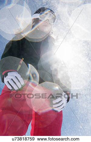 Stock Photo - Woman wearing skiwear in sunlight, low angle. Fotosearch