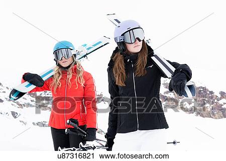 Women wearing helmets and ski goggles holding skis, portrait View Large Photo Image Stock Image - Women wearing helmets and ski goggles holding skis, portrait. Fotosearch