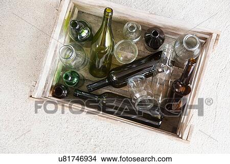 Picture - Wooden crate containing variety of empty bottles for recycling. Fotosearch