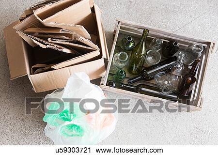 Stock Image - Wooden crate of empty bottles and cardboard box for recycling. Fotosearch