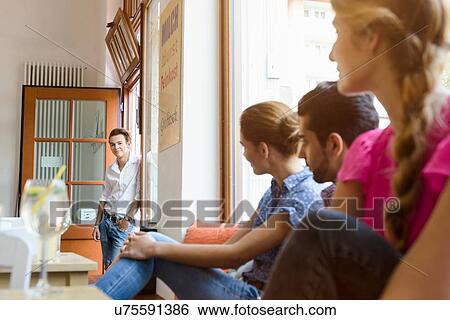 Young adult friends looking over at teenage boy in cafe doorway View Large Photo Image Stock Photograph - Young adult friends looking over at teenage boy in cafe doorway. Fotosearch