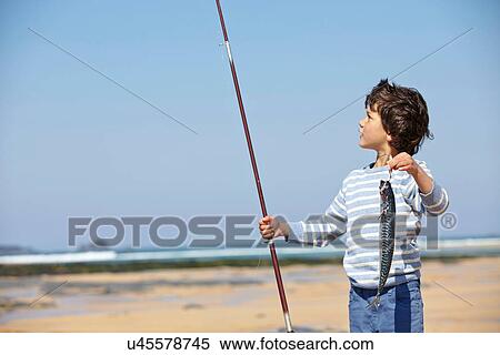 Stock Photography - Young boy holding up fishing rod and fish. Fotosearch