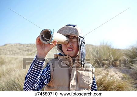 Young boy on beach, looking through pretend telescope View Large Photo Image Stock Image - Young boy on beach, looking through pretend telescope. Fotosearch