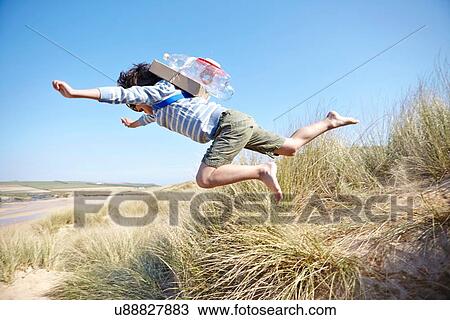 Young boy on beach, wearing fancy dress, leaping into air View Large Photo Image Stock Image - Young boy on beach, wearing fancy dress, leaping into air. Fotosearch