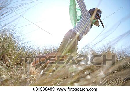 Young boy on beach, wearing fancy dress, pretending to fly View Large Photo Image Stock Photo - Young boy on beach, wearing fancy dress, pretending to fly. Fotosearch