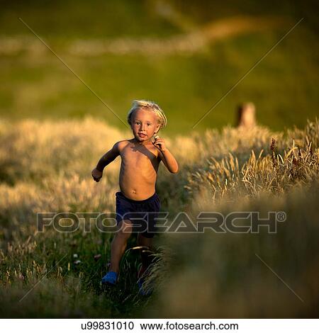 Young boy running through field View Large Photo Image Stock Image - Young boy running through field. Fotosearch