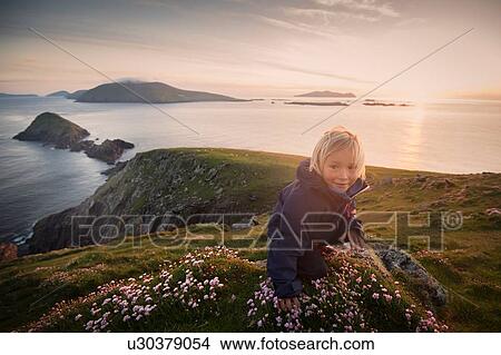Picture - Young boy sitting on hillside, Slea head, County Kerry, Ireland. Fotosearch