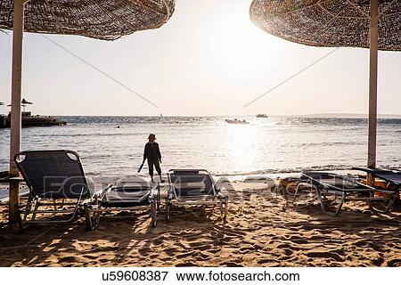 Stock Photo - Young boy walking along beach, Hurgada, Red Sea, Egypt. Fotosearch