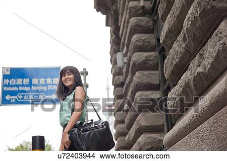 Young businesswoman, smiling, outdoors, Shanghai, China View Large Photo Image Picture - Young businesswoman, smiling, outdoors, Shanghai, China. Fotosearch