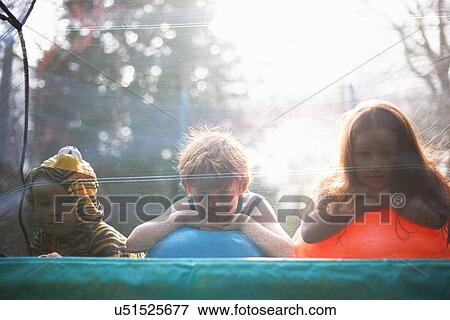 Young children looking out from garden trampoline View Large Photo Image Stock Photo - Young children looking out from garden trampoline. Fotosearch
