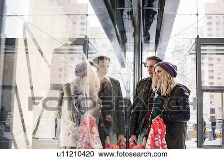 Young couple gazing at shop window with sale shopping bags, New York, USA View Large Photo Image Stock Image - Young couple gazing at shop window with sale shopping bags, New York, USA. Fotosearch