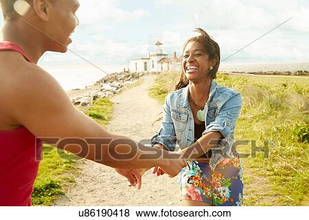 Young couple holding hands face to face smiling, fooling around View Large Photo Image Stock Photo - Young couple holding hands face to face smiling, fooling around. Fotosearch