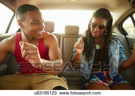 Young couple in back seat of car showing off dance moves View Large Photo Image Stock Image - Young couple in back seat of car showing off dance moves. Fotosearch